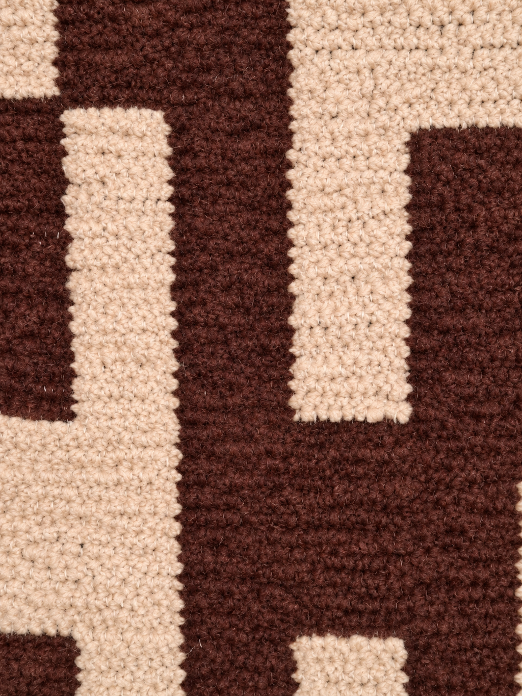 Detail van de structuur en het blokdessin in chocoladebruin en beige