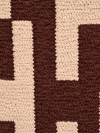 Detail van de structuur en het blokdessin in chocoladebruin en beige