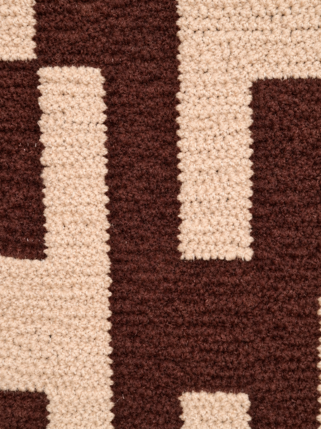 Detail van de structuur en het blokdessin in chocoladebruin en beige
