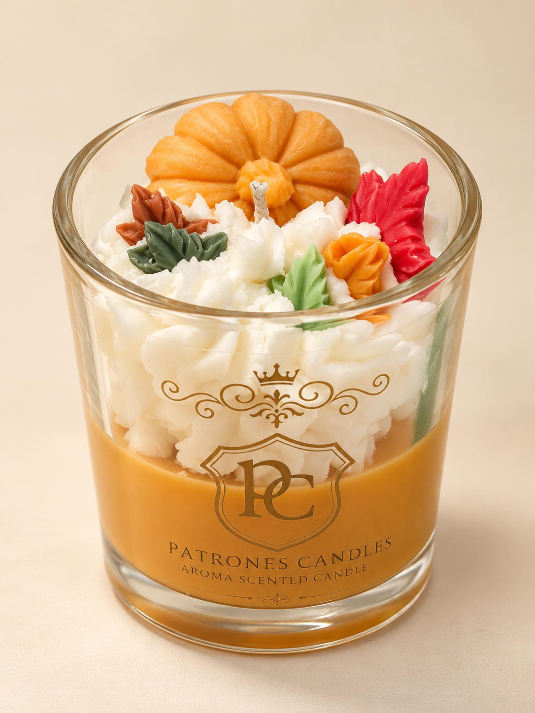Patrones Candles Pumpkin Spice geurkaars van sojawas in glas met gouden logo, oranje pompoen en kleurrijke herfstblaadjes.